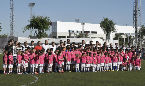 Foto de familia de los jugadores con alumnos de la Escuela de Football Antonio Puerta