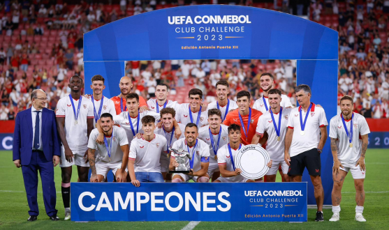 Sevilla FC pose with the Antonio Puerta Trophy and the UEFA CONMEBOL Club Challenge