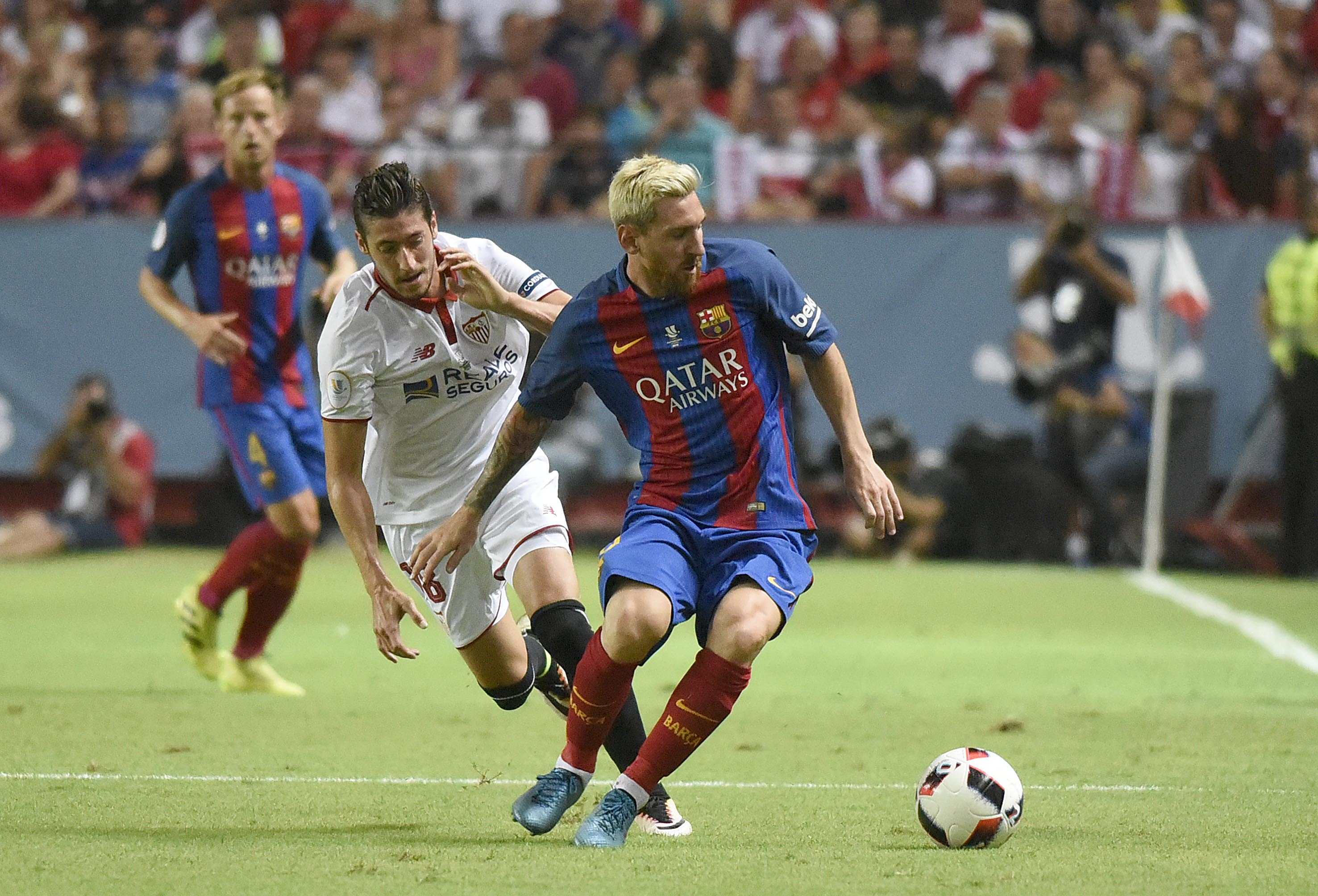 Escudero y Messi disputan el, balón