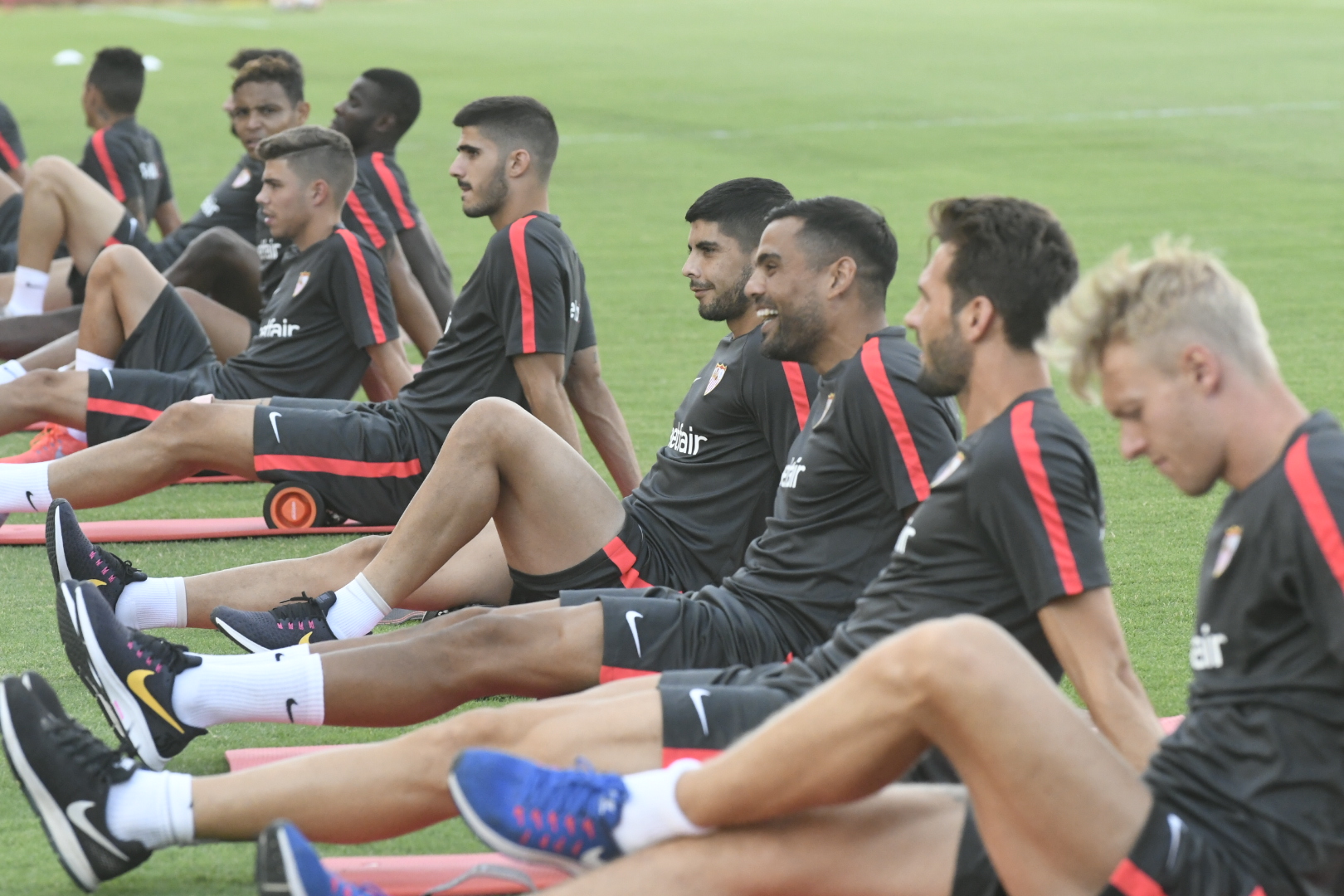 Los jugadores del Sevilla FC hacen estiramientos en el entrenamiento de este viernes