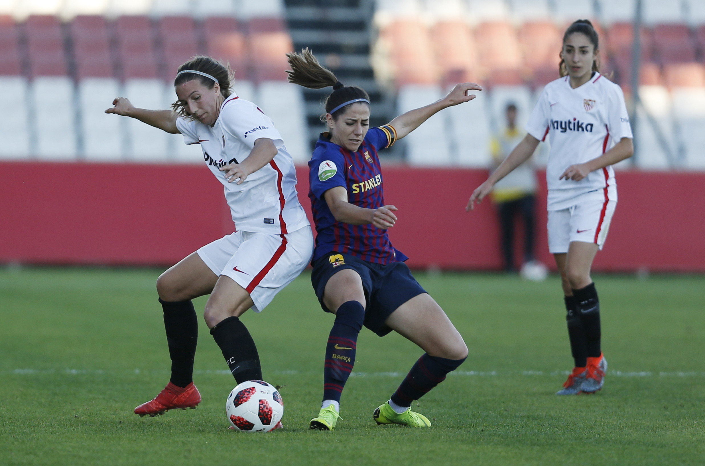 Jeni Morilla, del primer equipo femenino del Sevilla FC, pugna por el balón ante Vicky Losada, del FC Barcelona, durante el encuentro de la jornada 12 de la Liga Iberdrola