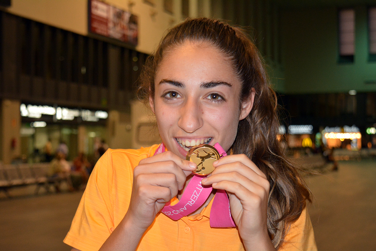 Olga Carmona, jugadora del primer equipo femenino del Sevilla FC, hace el gesto de morder la medalla de oro que la acredita como ganadora del Europeo sub-19, anoche en Santa Justa