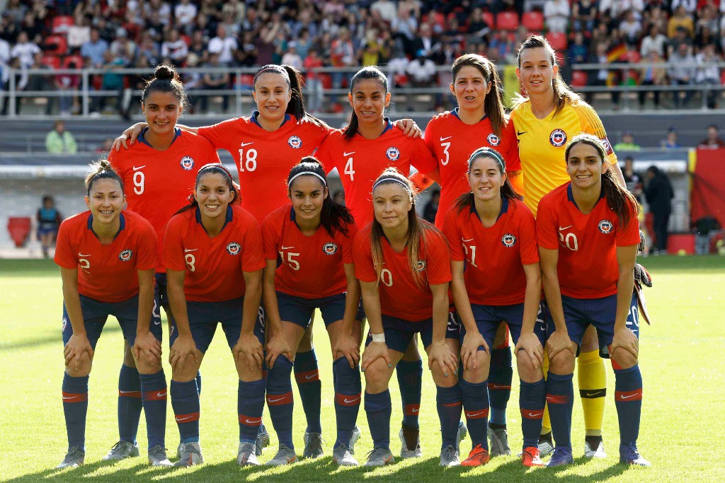 Pancha Lara, la tercera por la izquierda de pie; y Karen Araya, la segunda por la izquierda en la primera fila, ambas jugadoras del primer equipo femenino del Sevilla FC, posan en los prolegómenos del Alemania-Chile amistoso de este jueves