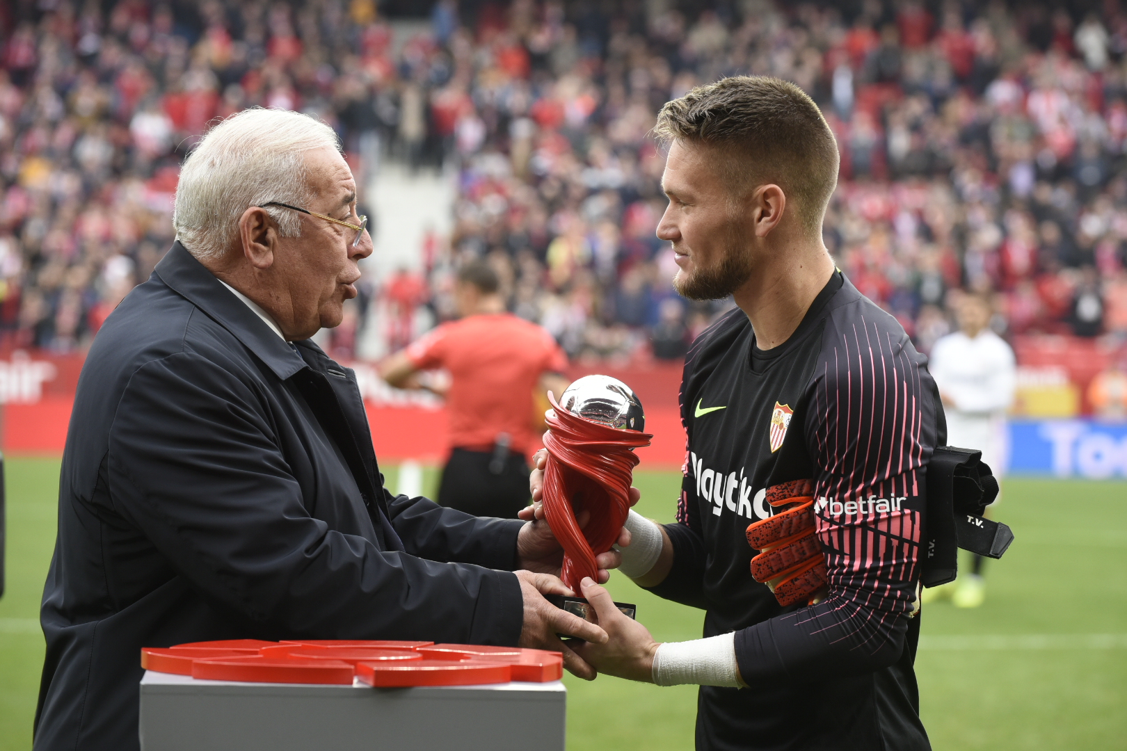 Súper Paco hands the trophy to Vaclík