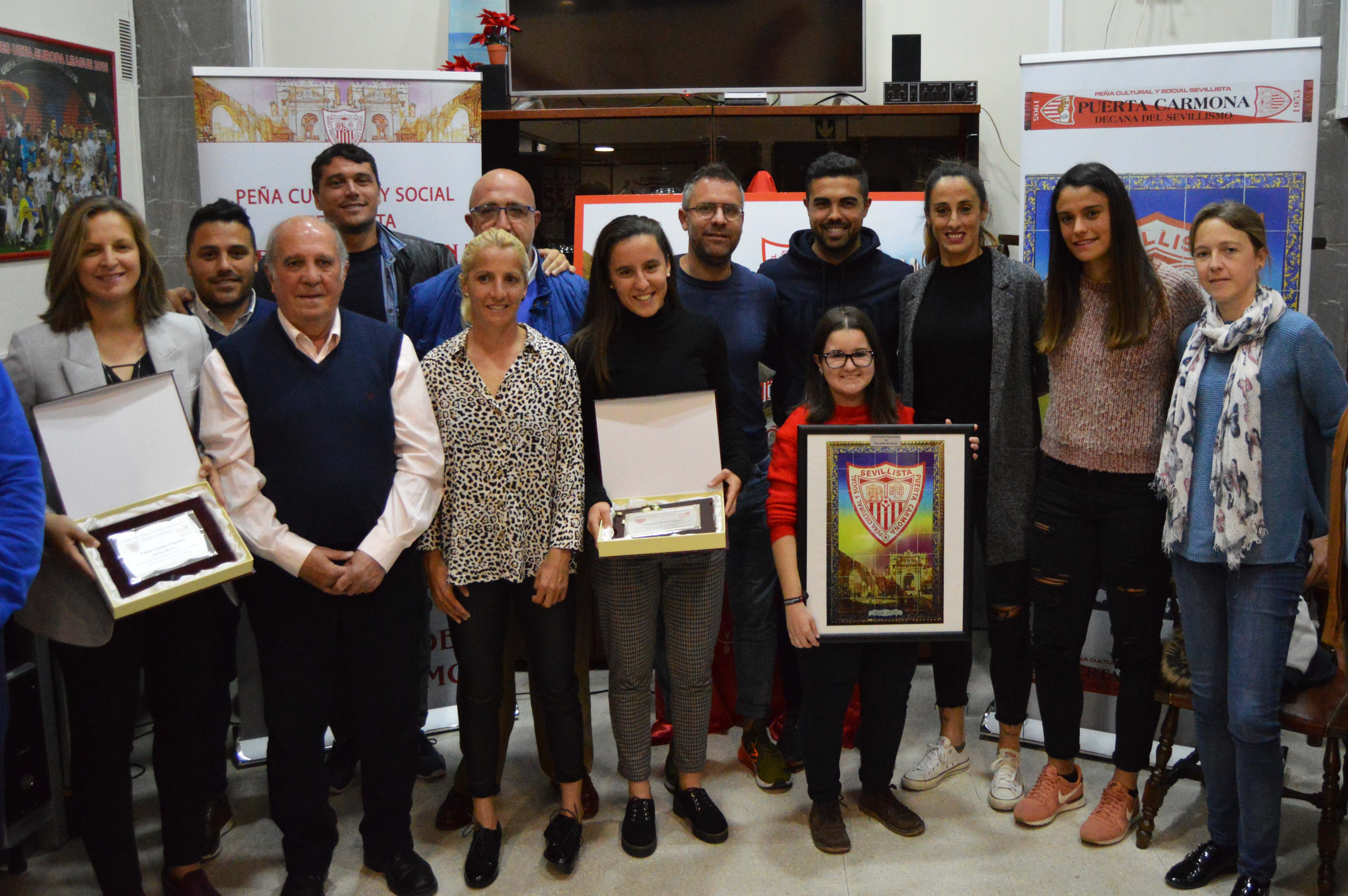 Representantes del Sevilla FC Femenino y de la PS Alicia Fuentes posan con sus respectivos obsequios tras el reconocimiento en la PS Puerta Carmona