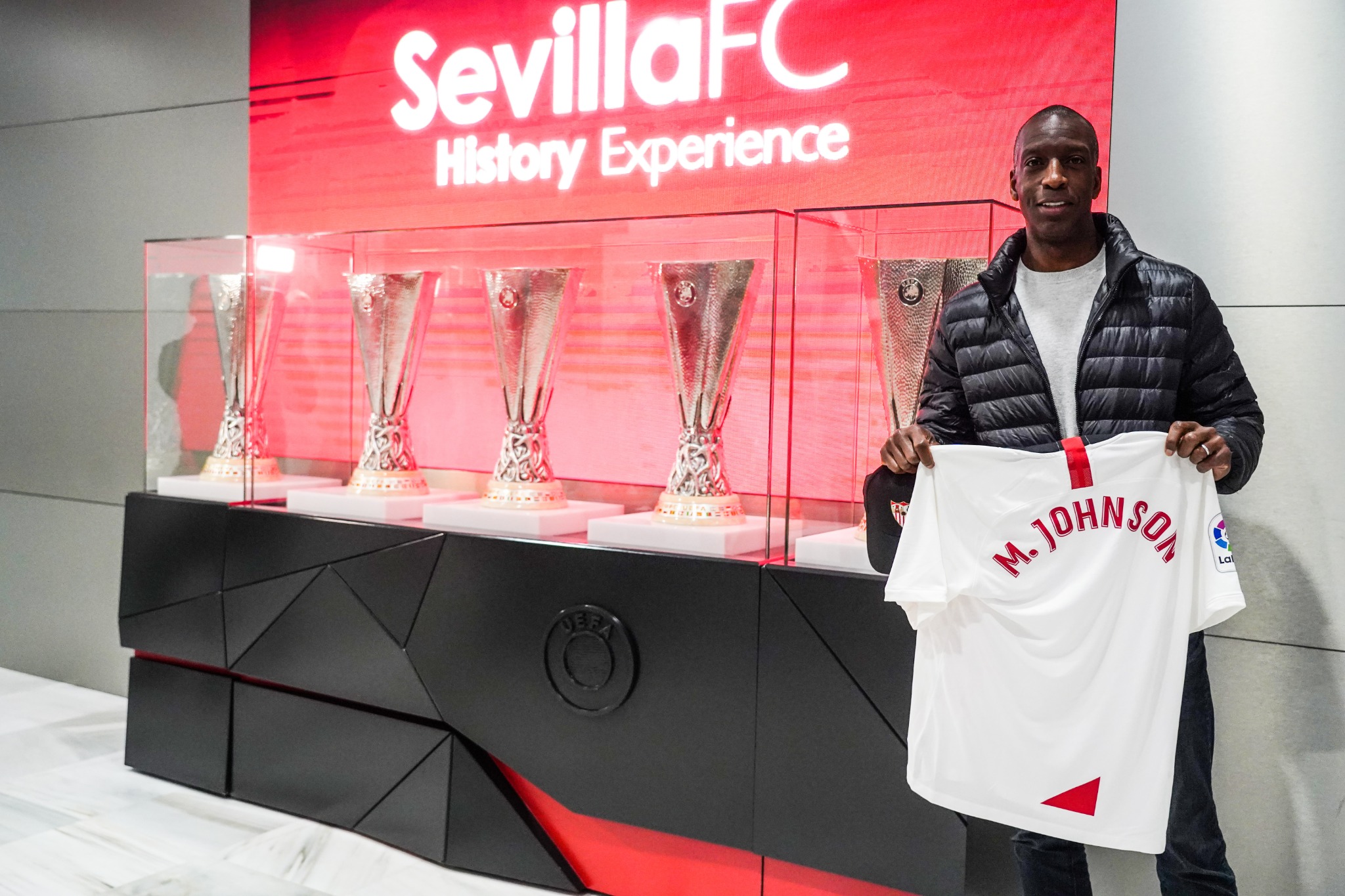 Michael Johnson poses with a Sevilla FC top