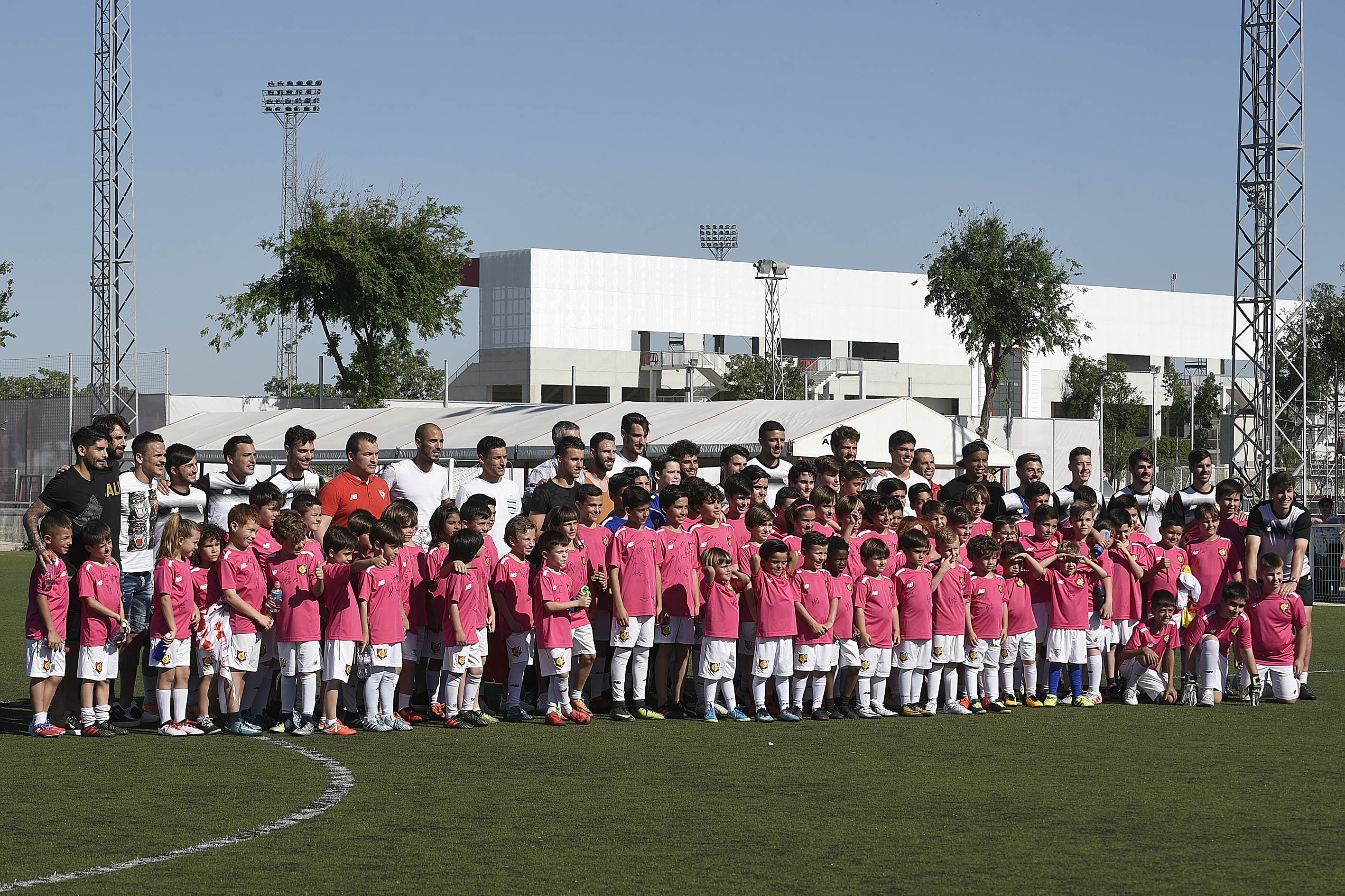 Foto de familia de los jugadores con alumnos de la Escuela de Football Antonio Puerta