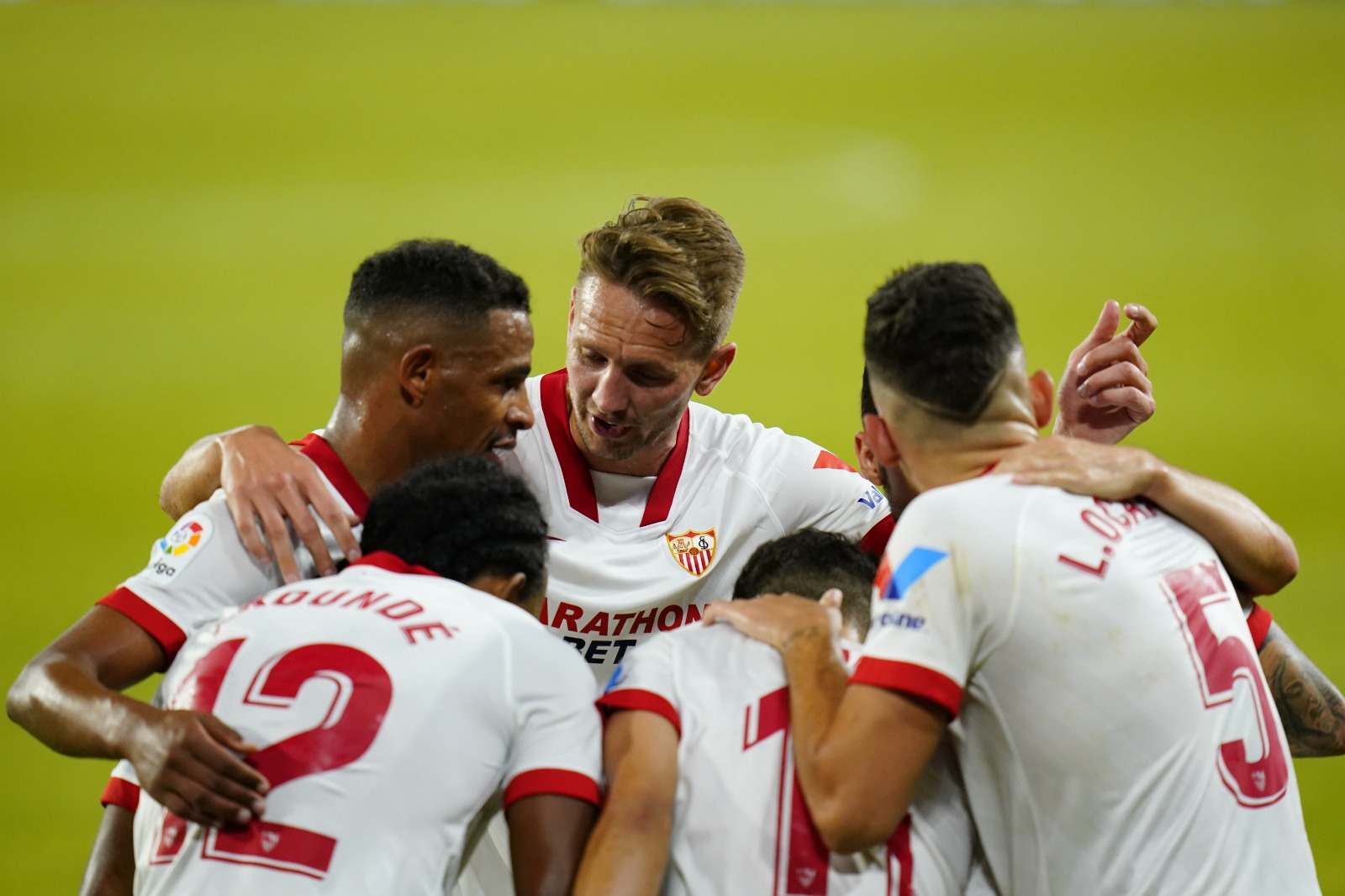 Piña de jugadores del Sevilla celebrando un gol