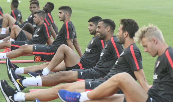 Los jugadores del Sevilla FC hacen estiramientos en el entrenamiento de este viernes