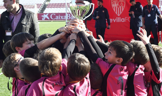 Los campeones levantan el trofeo sobre el césped del Estadio Jesús Navas